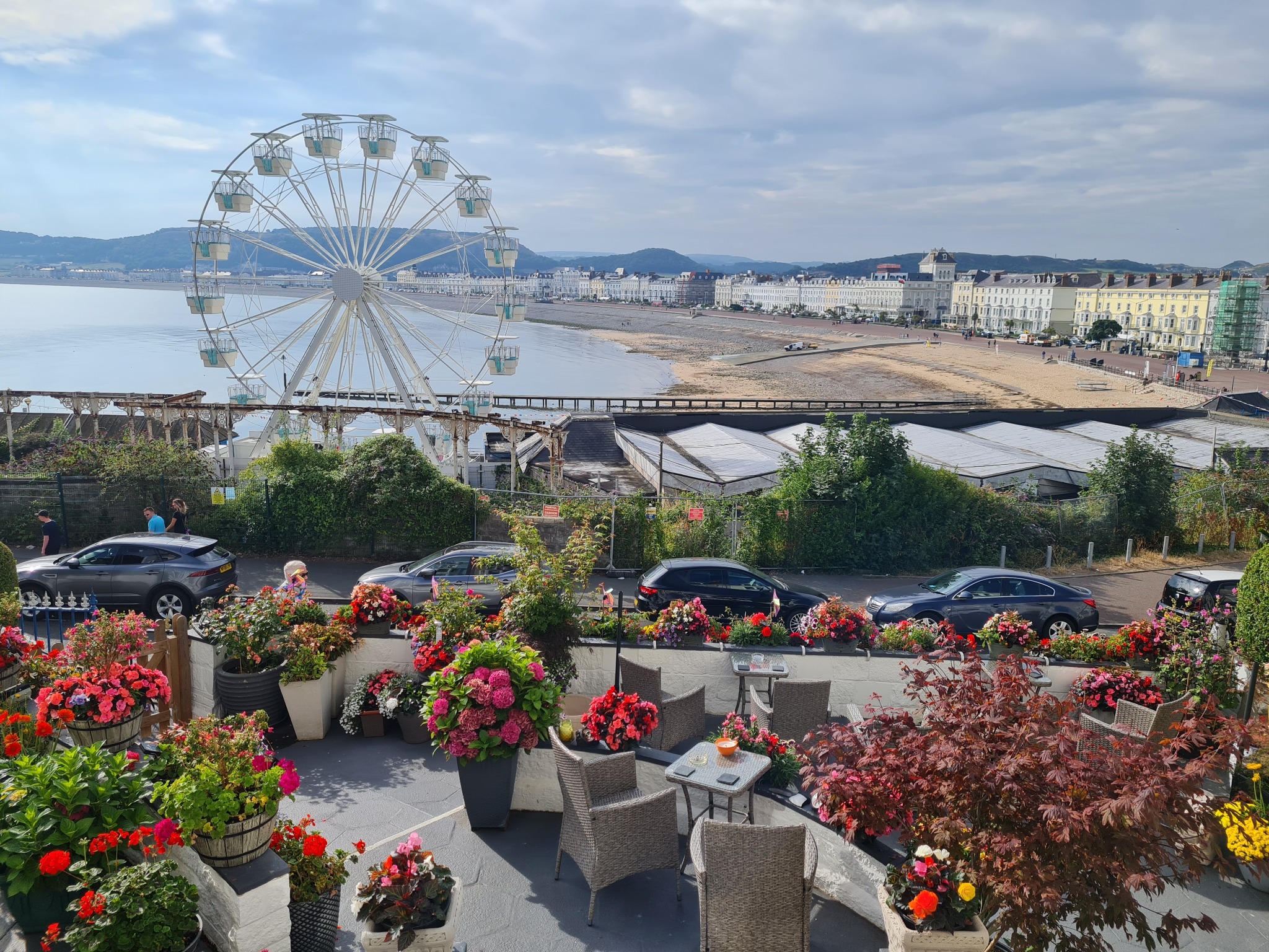 Flower-filled terrace at The View overlooking Llandudno Bay and the Ferris wheel